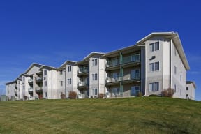Exterior of Sunset Trails Apartment Homes with balconies and green space to enjoy the outdoors.