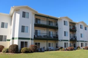 Exterior of The Meadows Apartments with multiple large windows and balconies.