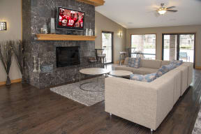 Community Room with Large Sofa, TV above Stone Fireplace