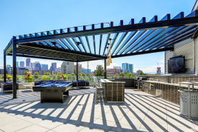 Sky deck at Westend Apartments featuring a full grilling station, billiards table, and island seating covered by a pergola.