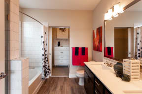 Bright and stylish bathroom with a full shower, double vanity sink, and quartz countertops. Bathroom leads into walk in closet.