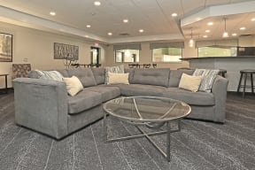 Community room sectional gray couch and glass coffee table