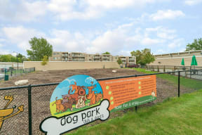 Woodchip dog park with large dog park sign on fence surrounding enclosure