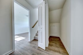 entry foyer with hardwood floors and white door wood rails leading upstairs