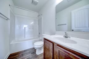 bathroom with hardwood floors and ceramic toilet and walnut vanity
