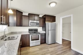 walnut cabinets with granite countertops and stainless steel appliances hardwood floors kitchen  at Franklin Square Apartments/Townhomes, New Freedom, PA