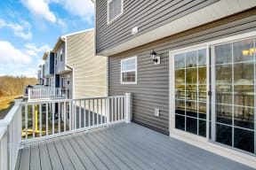 composite deck with white railing off kitchen sliding glass doors country view  at Franklin Square Apartments/Townhomes, Pennsylvania, 17349