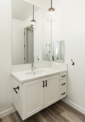 Bathroom floating vanity. White with brass hardware and hanging pendant light
