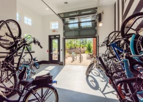 Bicycle workshop in modern garage with vaulted ceilings, high windows, and bikes hanging on the wall
