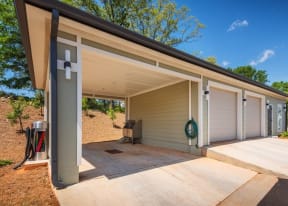 Covered outdoor space with access to a hose, car vacuum, and utility sink near garages