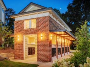 Well-lit indoor/outdoor community mail building enclosed with brick walls and columns