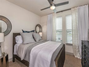 Model bedroom with carpeted flooring and two window in Orlando, FL apartment for rent