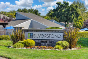 Silverstone Apartments Monument Sign with Flower Beds, Grass and Apartment Exterior