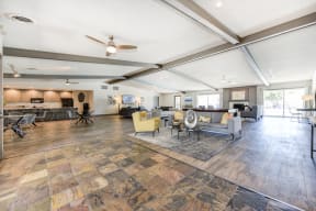 Clubhouse Sitting Area with Hardwood Inspired Floor, Gray Sofa, Rug and Ceiling Fan/Light