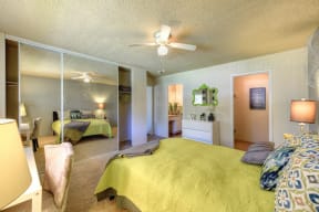 Living Room with View of Bathroom, Mattress with Green Comforter,  and Carpet at Pinecrest Apartments, Davis