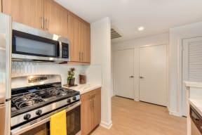 Kitchen with Gas Stove, Refrigerator and Wood Cabinets