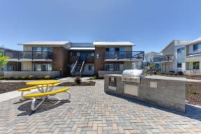 Outdoor Lounge Space with Red Picnic Table, Trees, Wood Chip Floor, Apartment Exterior