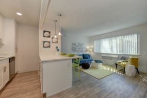 Kitchen with View of Living Room, Hardwood Inspired Floors, Green Chairs, Refrigerator at Pinecrest Apartments, California