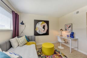 Bedroom with Daybed , White Desk, White Chair, Colorful Rug and Yellow Foot Stool