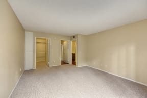 Bedroom with Large Closet with Carpet and Tan Walls