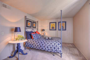 Bedroom with Large Window, Carpett, Bed with Black and White Pattern Comforter, Two Pictures of Vases on Wall