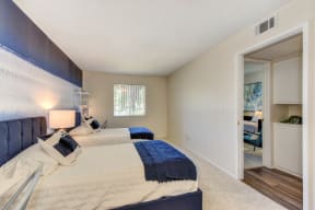  Bedroom with 2 twin beds with blue and white bedding.  Washer and dryer visible in hallway