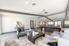 Clubhouse Sitting Area with Couches, White Tables and Pool Table in Distance