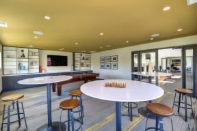 Community Clubhouse Game Room with Round Desk, Stools, Chess Set, Mounted Flatscreen Television 