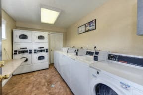 Community Laundry Room with Washers and Dryers, Hardwood Inspired Floors and Ceiling Light