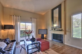 Model Apartment home with fireplace, hardwood inspired flooring and with views out the windows of the property grounds.