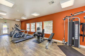 Fitness Center with Orange Walls, Ellipticals, Treadmills, Yoga Balls and Hardwood Inspired Floors 