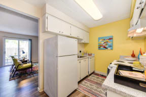 Kitchen with Refrigerator, Bright Yellow Accent Walls, Hardwood Inspired Floors and Refrigerator