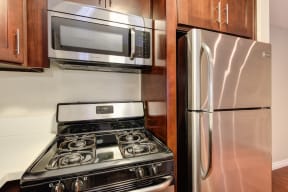 Kitchen with Wood Cabinets, Stove, Refrigerator and Microwave