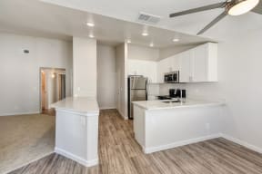 Kitchen with View of Entryway, Wood Inspired Floors, Ceiling Fan/Light and Refrigerator