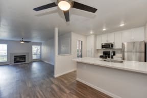 Kitchen with Wood Inspired Floors, Ceiling Fan/Light, Refrigerator, View of Living Room andWhite Counter