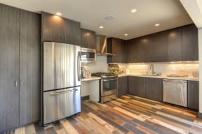Leasing Office Kitchen with Hardwood Inspired Floors and Stainless Steel Refrigerator, Wood Inspired Floor, Wood Cupboards, Oven, Stove, Microwave