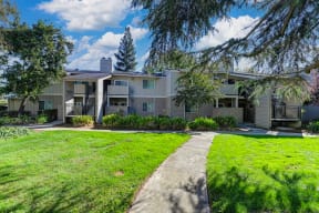 Monte Bello Community grounds with mature tress and landscaping around the building.  Concrete walk path through out the community.