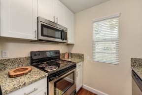 Kitchen with Granite Counters, Hardwood Inspired Floors, Microwave and Oven