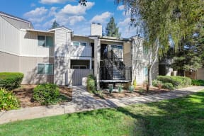 Monte Bello apartment building 2 levels and mature shade tree located in front of the building.