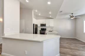 White Kitche with Hardwood Inspired Floor, White Counter and Ceiling Fan/Light