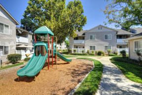 Outdoor Playground located in between apartment buildings .