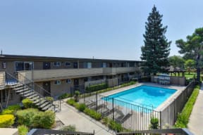 Outdoor Swimming Pool, Trees, Bushes and Apartment Exteriors