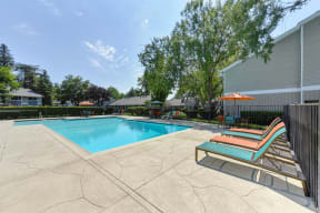 Pool Area with Lounge Chairs, Trees and Apartment Exteriors at Pinecrest Apartments, California