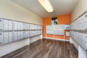 Community Mail Room.  Room is wall-to- wall with locked mailboxes and contains an orange colored accent wall.