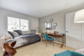 Spare Bedroom with Gray Daybed, Carpet, Wood Table, Turquoise Chairs and Windows