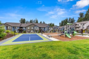Tennis Courts and Playground, Wood Chip Floor, Grass, and Apartment Exteriors