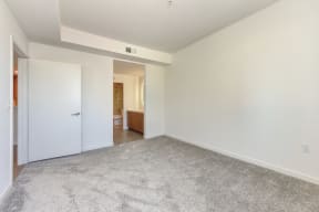 Vacant bedroom with carpeting and views to the bathroom
