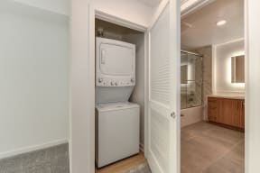 Washer and dryer inside the home located inside of a closet with a door. 