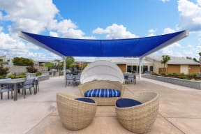 Outdoor Lounge with Wicker Chair, Blue Sun Cover, Tables and Chairs, Blue Sky with Clouds