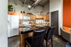 spacious apartment kitchen with ample storage, an island, and a dishwasher at East End Lofts